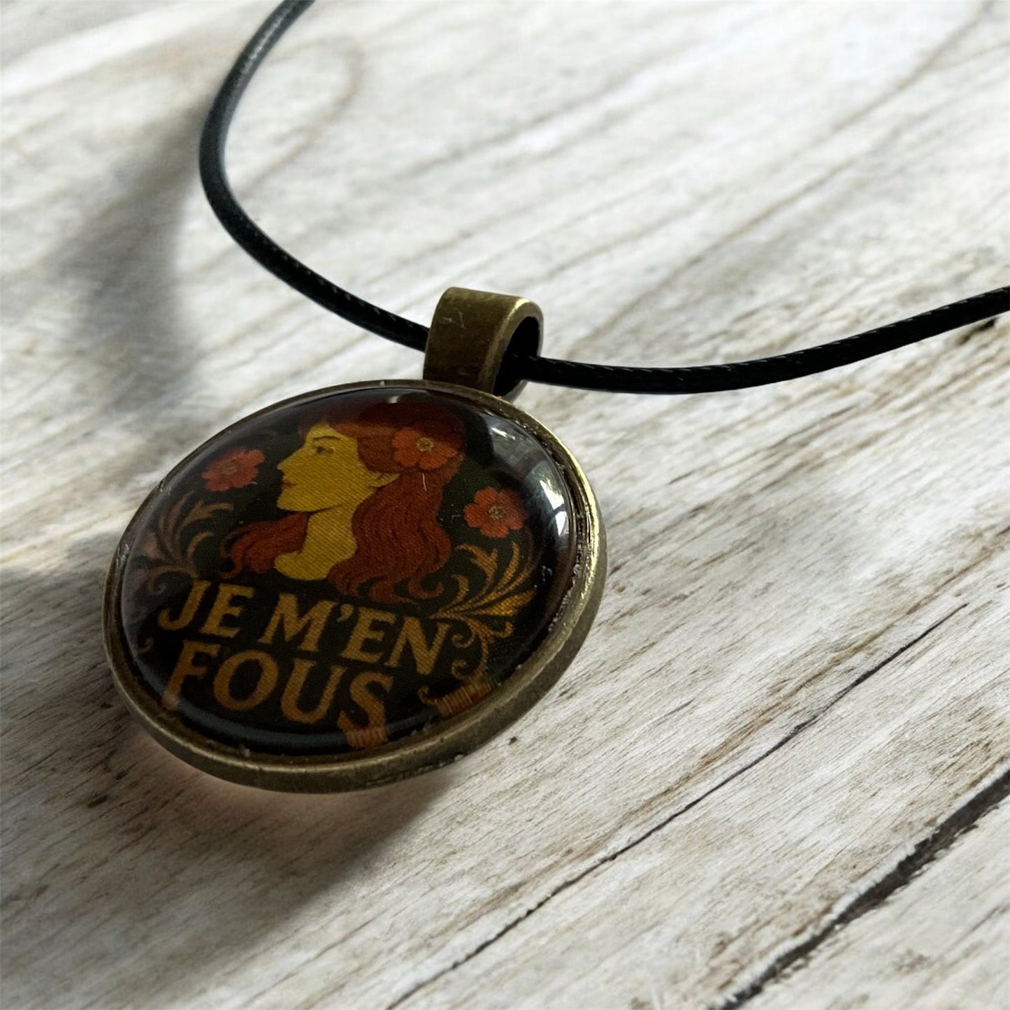 Cheeky “Je m’en fous” pendant with black cord necklace